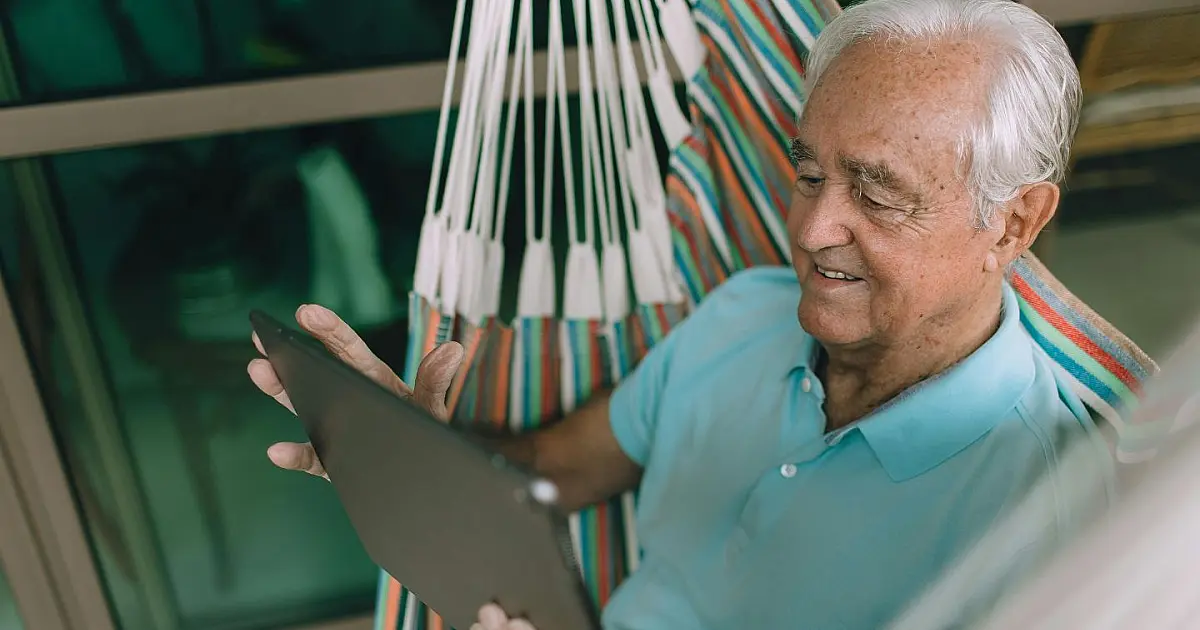 Idoso sentado em uma rede representando tranquilidade e os direitos garantidos a partir dos 60 anos.