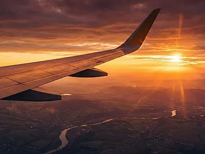 Asa de avião durante voo internacional que conecta turistas ao Brasil.