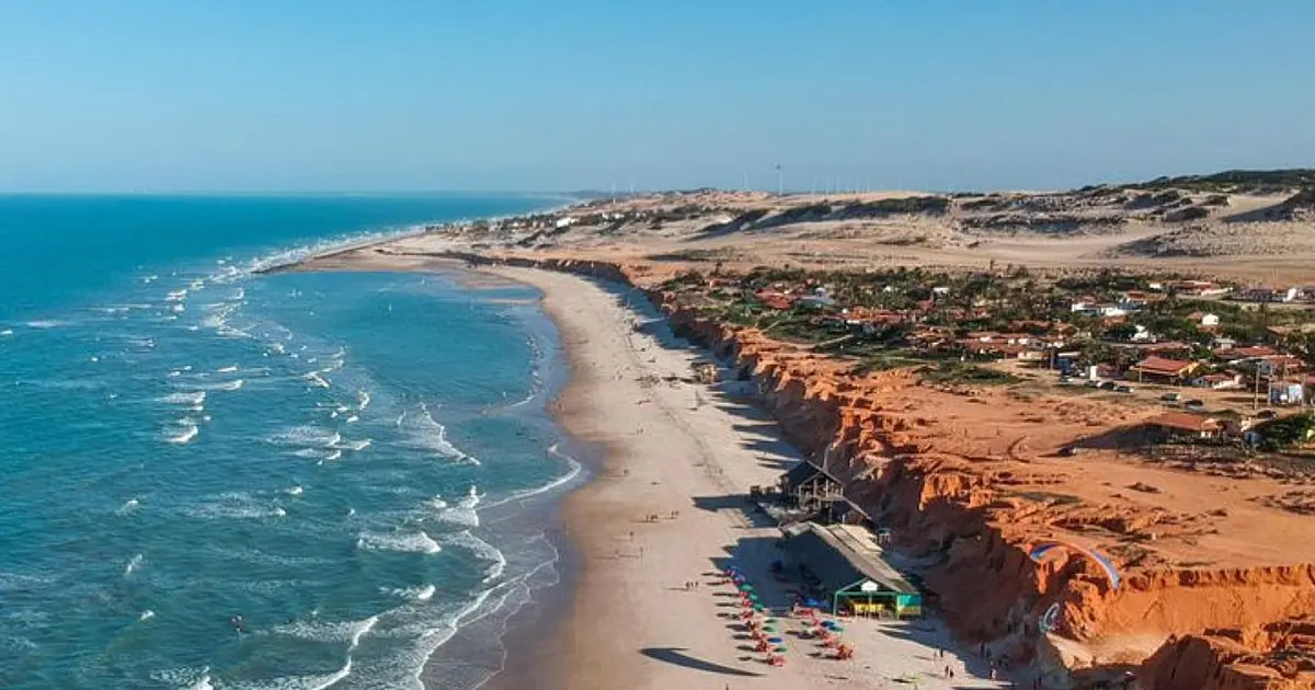 Praia de Canoa Quebrada com falésias vermelhas e mar verde no litoral do Ceará.