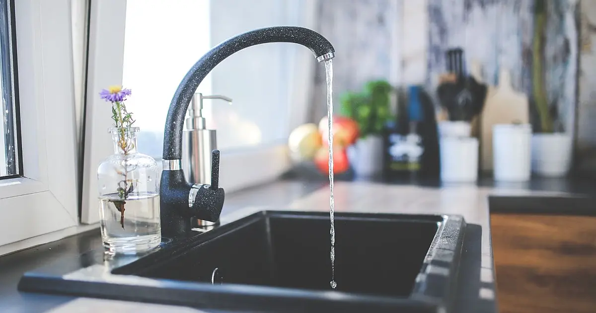 Residência com torneira aberta simbolizando a proibição do corte de água para famílias com pessoas doentes.