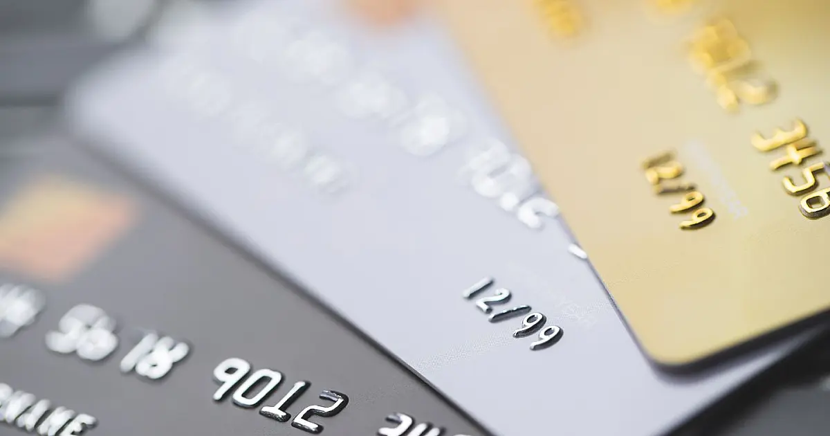 Cartões de crédito sobre mesa ilustrando impactos financeiros de dívida ativa.