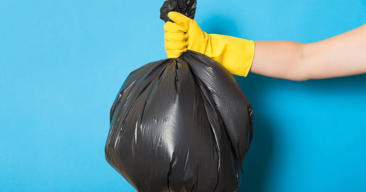 Lixeira de banheiro com saco plástico sendo trocado