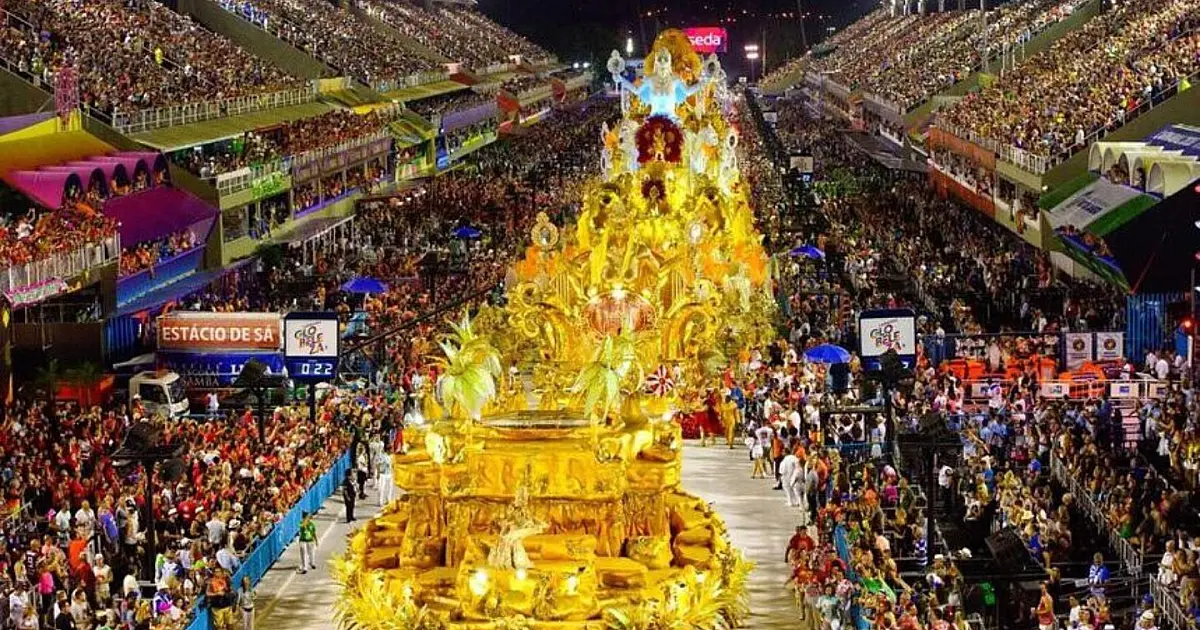 Escola de samba desfila na avenida durante apresentação de Carnaval.