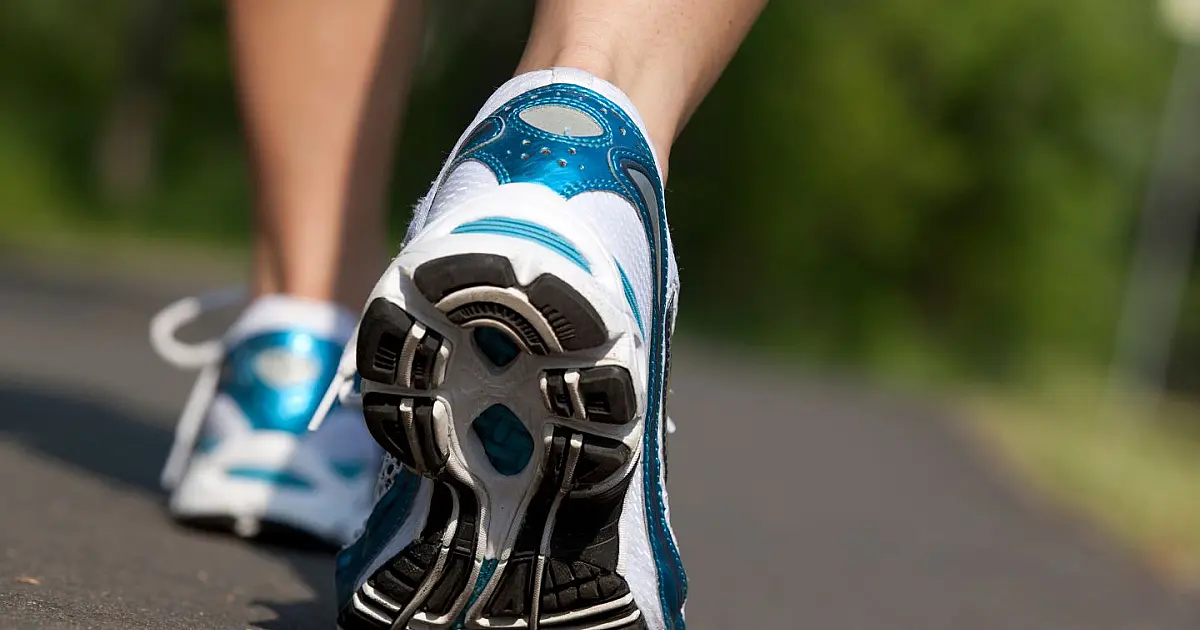 Pessoa caminhando ao ar livre em horário adequado para prática de atividade física e promoção da saúde.