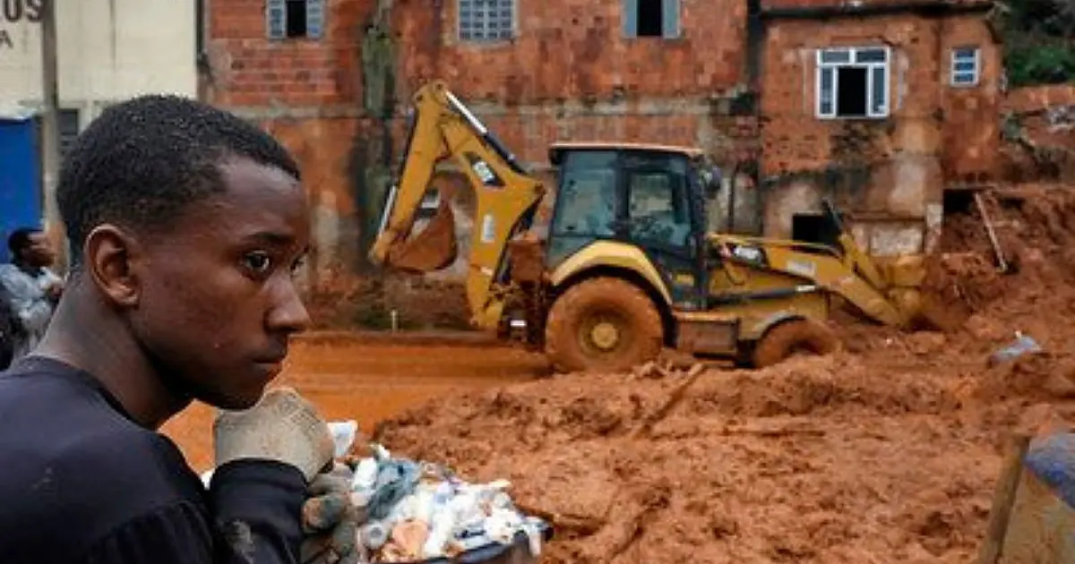 Homem ajudando na limpeza de área atingida por enchente em Minas Gerais