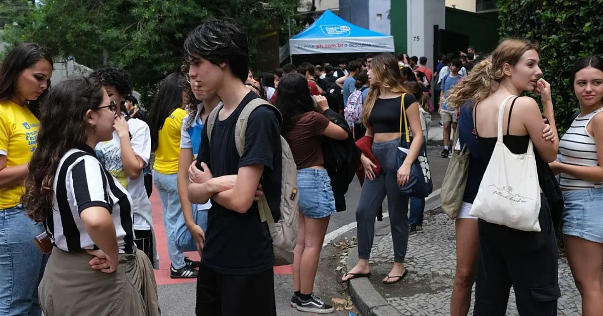 Grupo de estudantes na entrada de uma escola pública no Brasil.