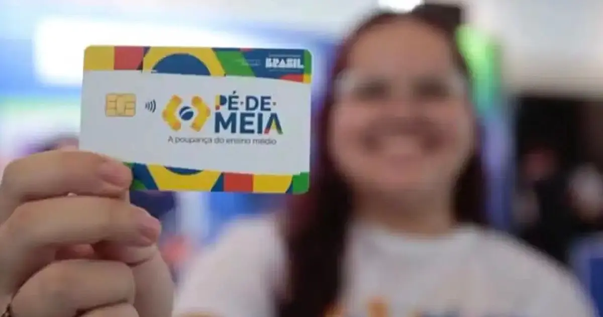 Pessoa segurando cartão do programa Pé-de-Meia do Ministério da Educação.