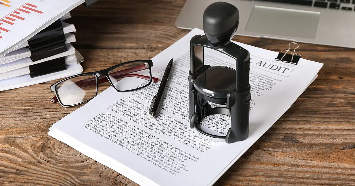 Carimbo e documentos de cartório sobre mesa de madeira