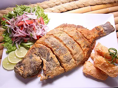 Peixe frito servido em quiosque da orla de João Pessoa, onde preços variam conforme o estabelecimento.