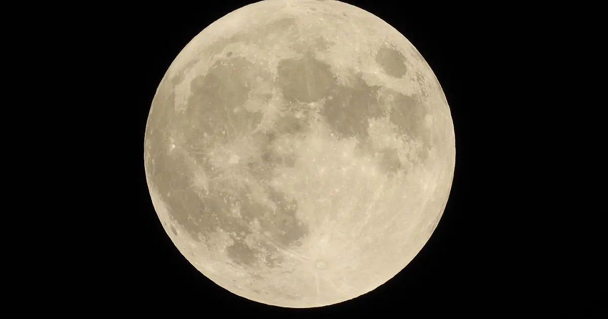 Lua cheia no céu noturno que pode adquirir coloração avermelhada durante eclipse lunar total.