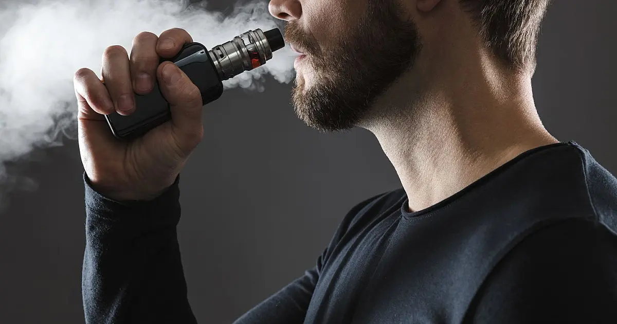 Pessoa utilizando cigarro eletrônico em meio a alerta da Anvisa sobre a proibição do vape no Brasil.