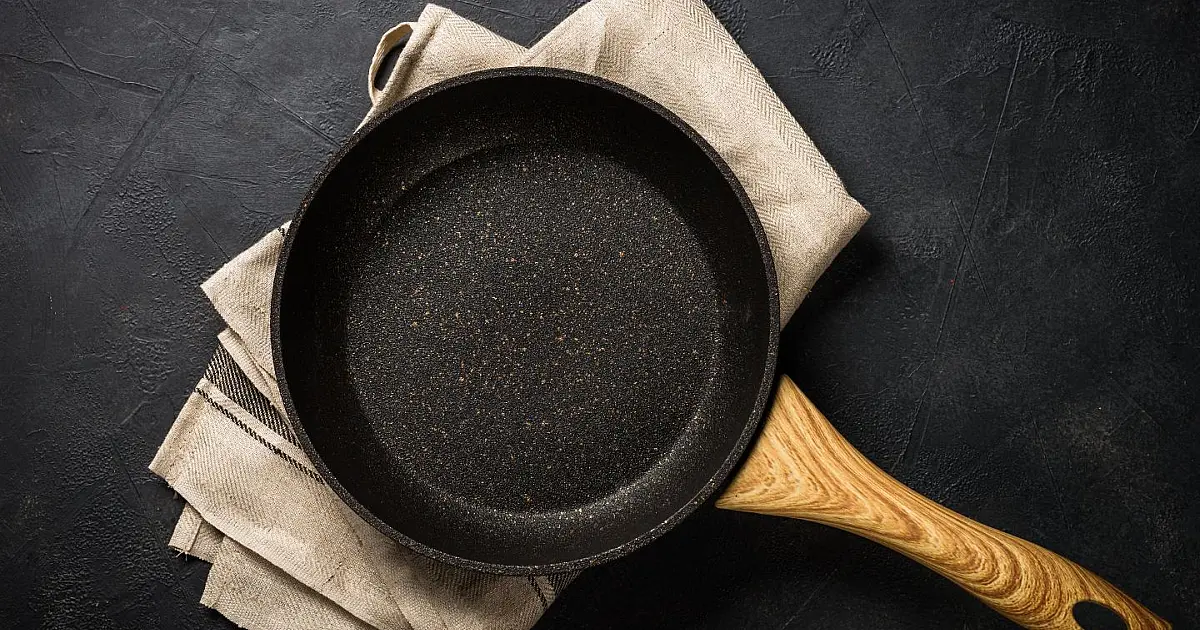 Frigideira aquecida sobre fogão durante preparo de alimento.