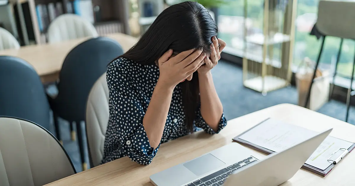 Jovem profissional com expressão de estresse no ambiente de trabalho