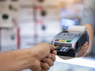 Uso de cartão de crédito em máquina de pagamento ilustra modalidade de cartão consignado