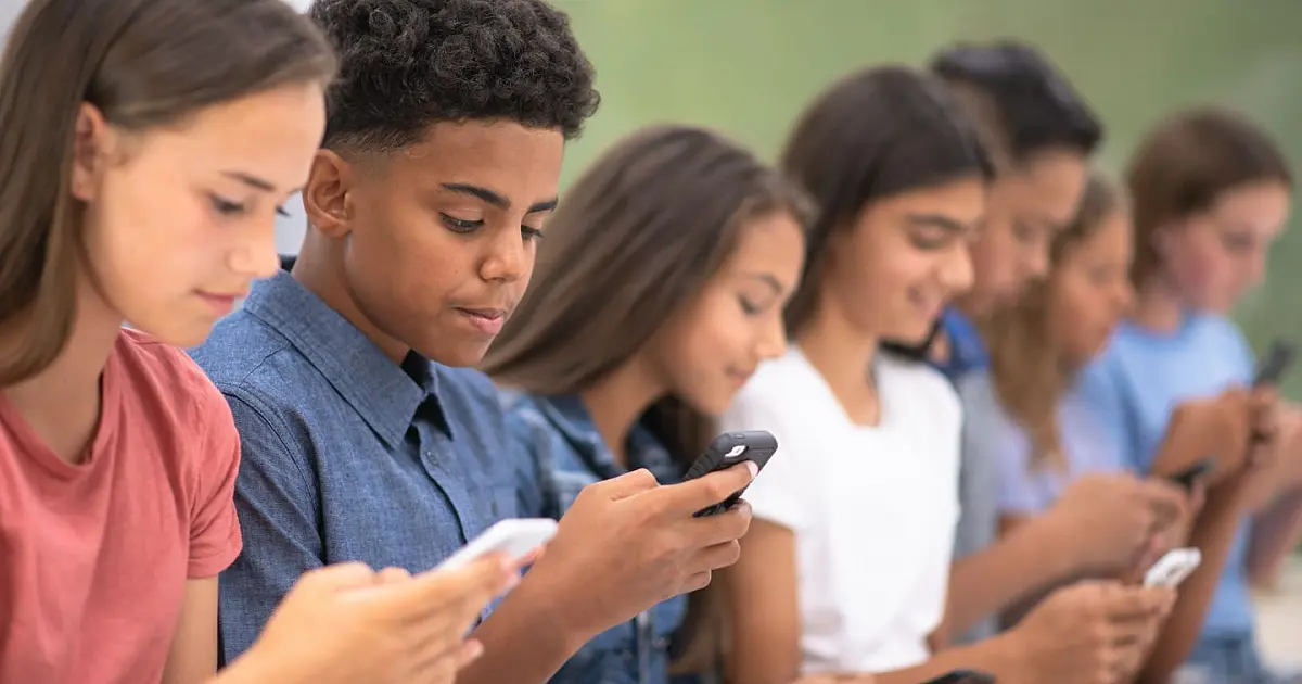 adolescentes utilizando celulares em ambiente escolar