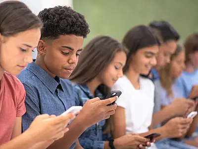 Estudantes utilizam celulares, tema debatido após regulamentação do uso nas escolas.