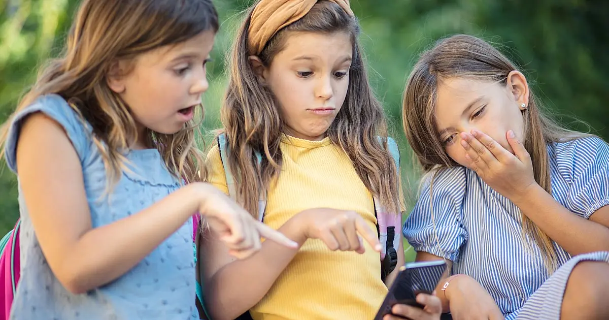Crianças utilizando celular e acessando aplicativos.