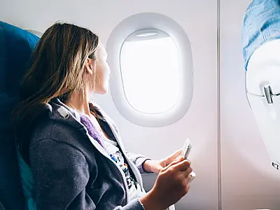 Passageira utiliza celular dentro de avião após ativar o modo avião durante o voo.