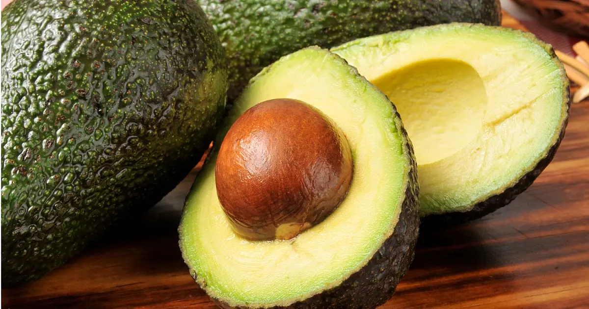 Abacate inteiro sobre mesa de cozinha representando dicas de armazenamento da fruta.