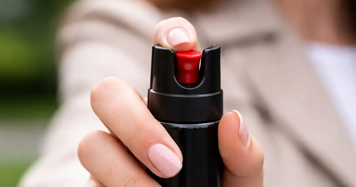 Mulher segurando spray de pimenta utilizado para defesa pessoal