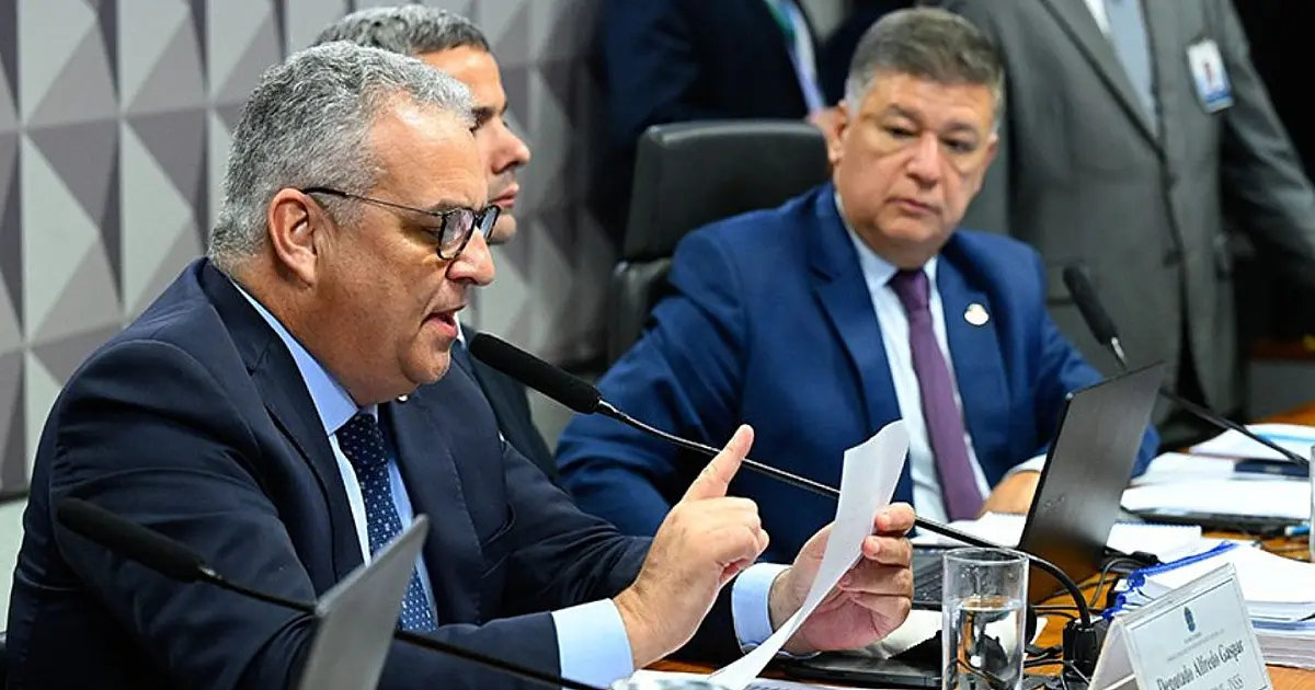 Deputado Alfredo Gaspar lê relatório da CPMI do INSS enquanto o senador Carlos Viana acompanha a sessão.