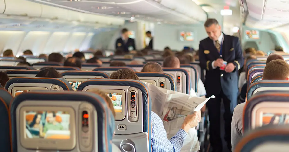 Passageiros sentados dentro de avião durante voo comercial.