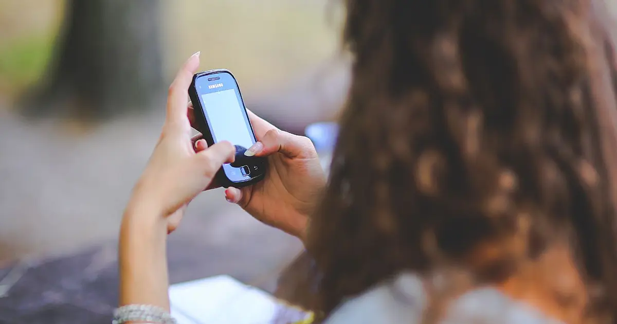 Adolescente utilizando celular enquanto navega em redes sociais em discussão sobre regras do ECA Digital