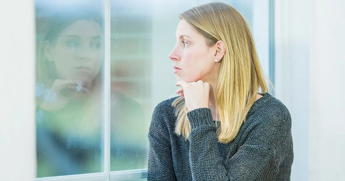 Mulher sentada sozinha refletindo sobre questões emocionais.