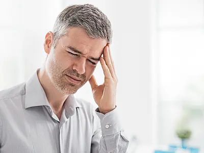 Homem com dor de cabeça, sintoma comum da desidratação