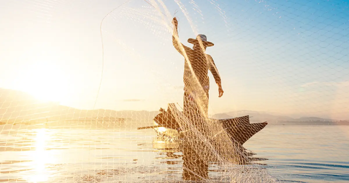 Homem pescando em rio representando pescadores beneficiados pelo Seguro Defeso.