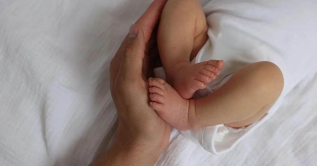 Mãe acariciando bebê representando processo de adoção e formação de família.