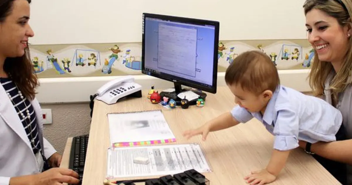 Profissional de saúde atendendo mãe e criança em unidade do SUS durante acompanhamento do desenvolvimento infantil.
