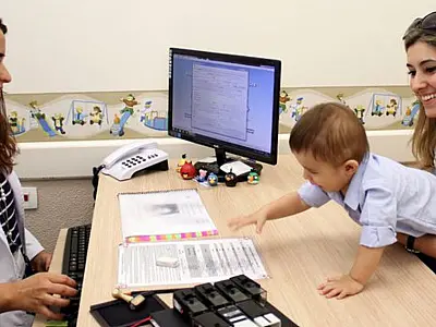 Profissional de saúde orienta mãe durante atendimento sobre cuidados com o desenvolvimento infantil.