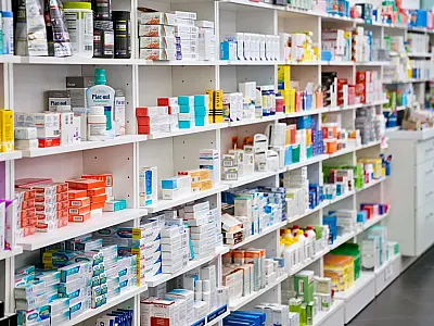 Prateleiras de farmácia com diversos medicamentos disponíveis para venda.