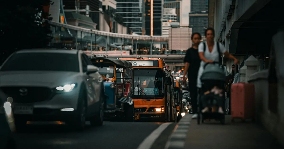 Tráfego de veículos em avenida movimentada com várias faixas de trânsito.