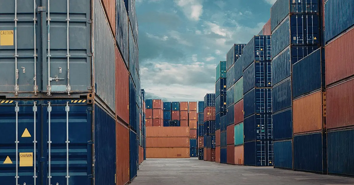 Contêineres empilhados em terminal portuário representando operações logísticas