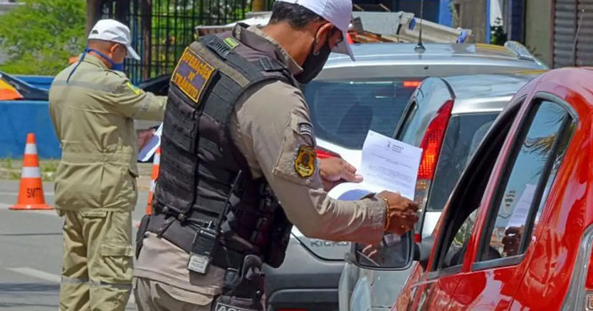 Agentes de trânsito realizando fiscalização em via urbana.