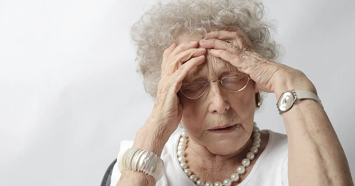 Mulher com dor de cabeça representando problemas relacionados ao uso de medicamentos para dormir