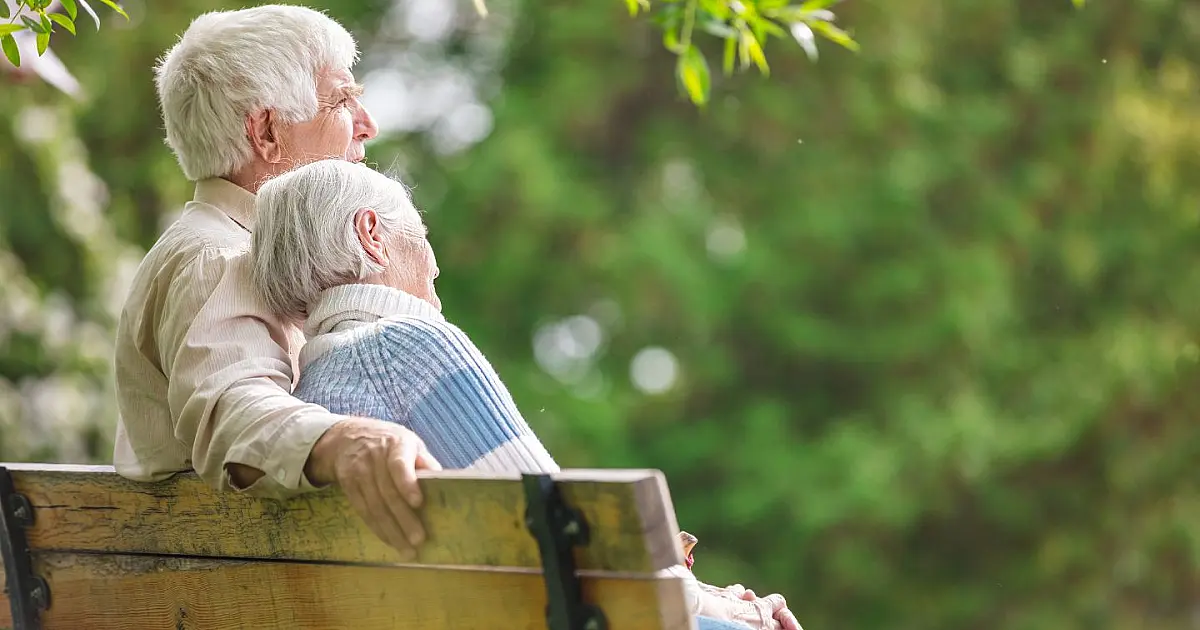 Casal de idosos caminhando em parque ao ar livre