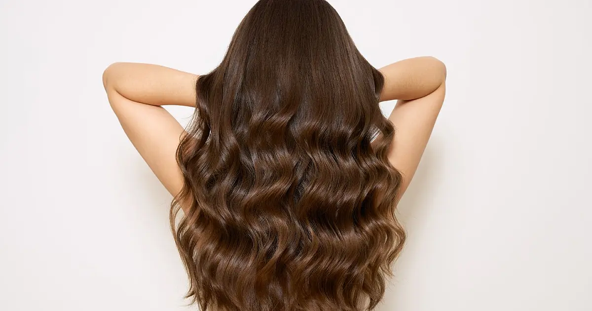 Mulher com cabelo longo representando a função dos folículos capilares na pele