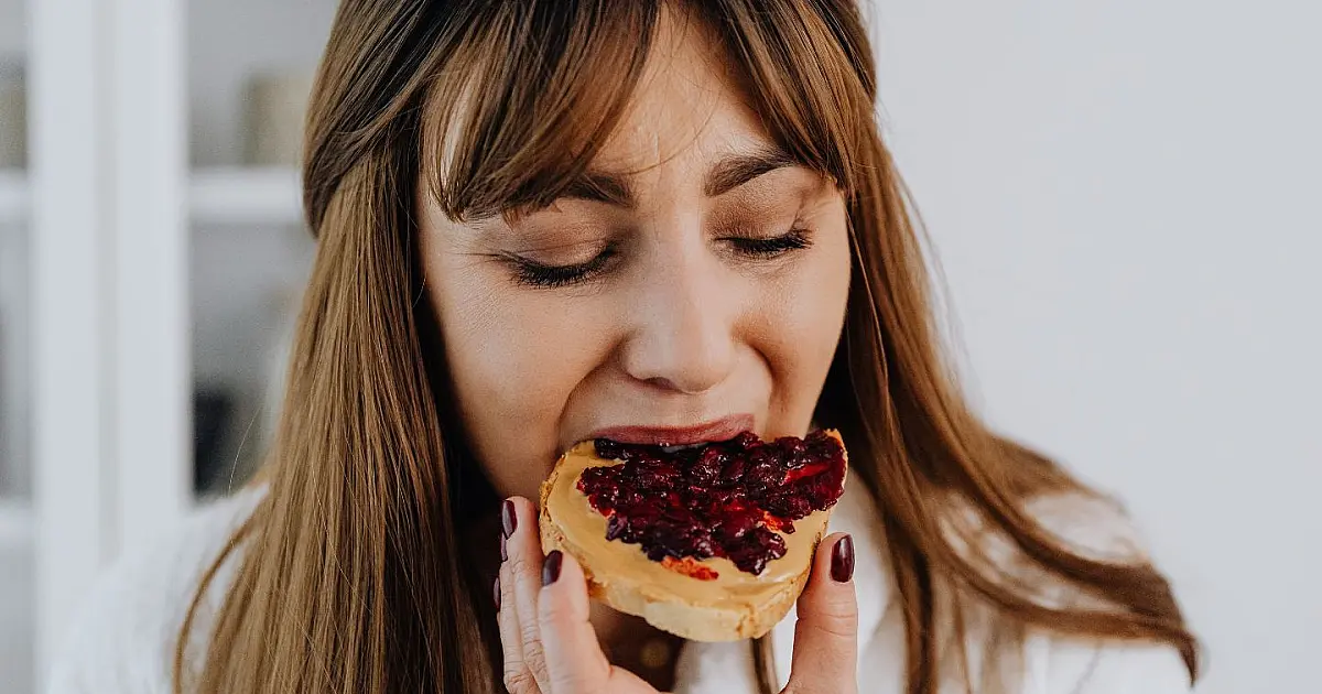 Pessoa comendo pão representando hábitos alimentares após o almoço.
