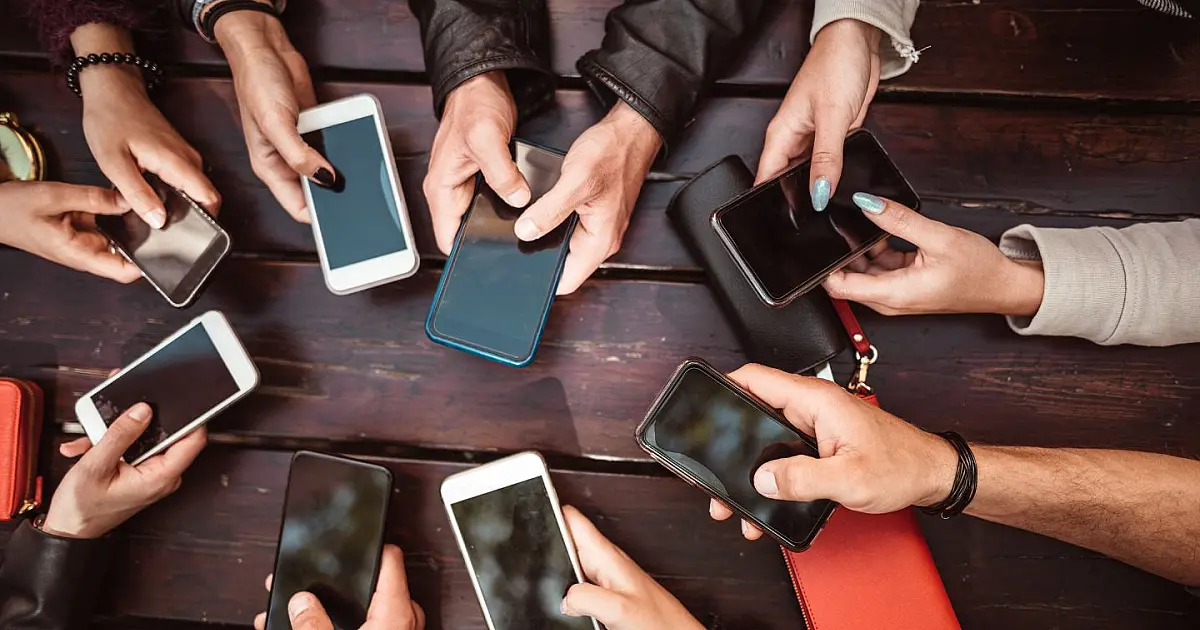 Pessoa jovem usando celular representando debate sobre redes sociais para menores.