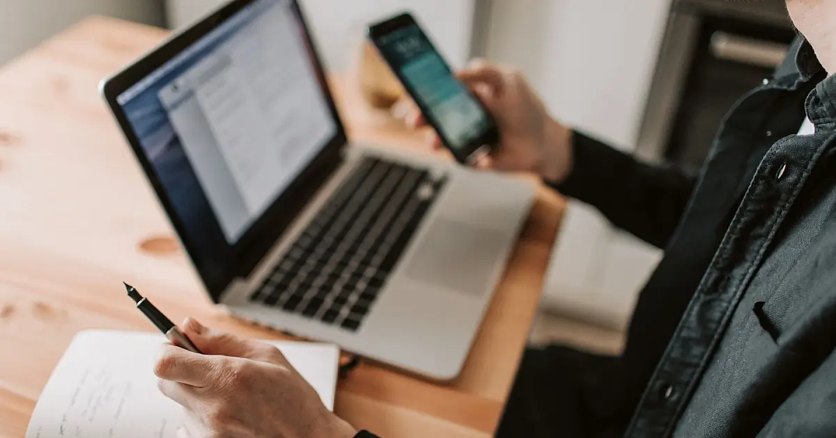 Pessoa segurando celular enquanto verifica ligação no WhatsApp supostamente feita por banco.