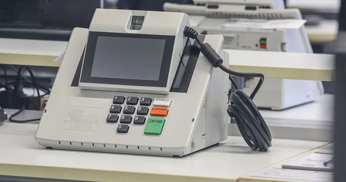 Pessoa utilizando urna eletrônica durante processo de votação no Brasil.