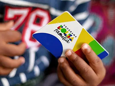 Criança segura cartão do programa Bolsa Família
