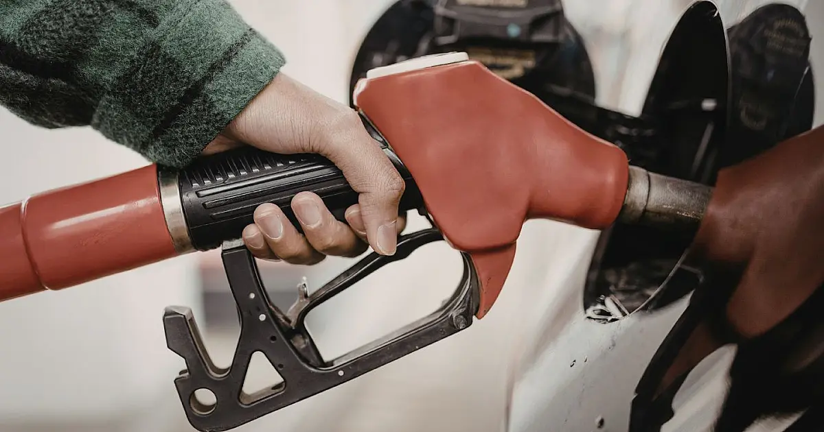 Pessoa abastecendo veículo em posto de combustíveis durante promoção.