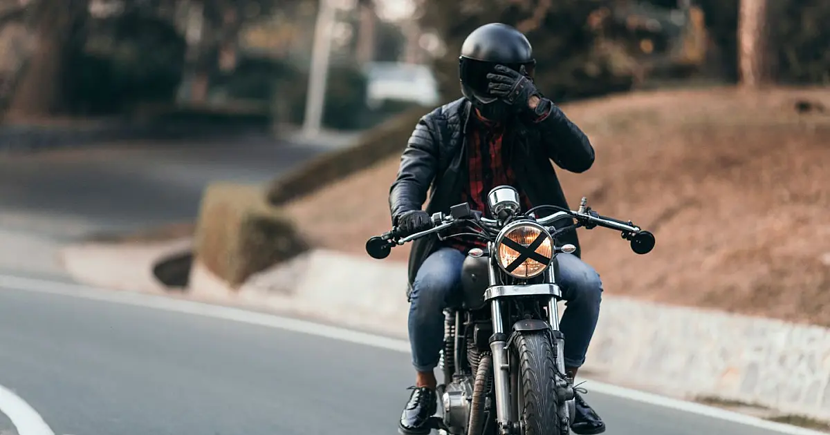 Motociclista usando capacete com foco em nova exigência de selo digital no Brasil.