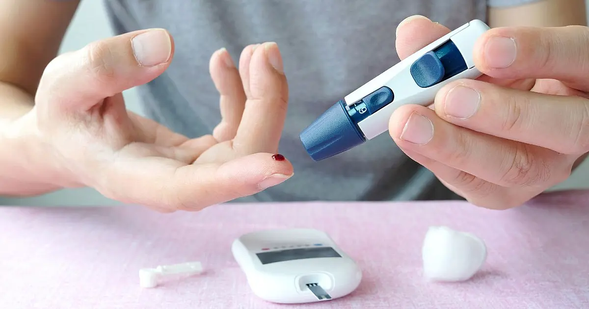 Pessoa medindo nível de glicose no sangue com aparelho digital