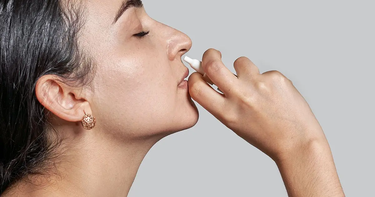Mulher utilizando spray nasal representando tratamento experimental para memória.
