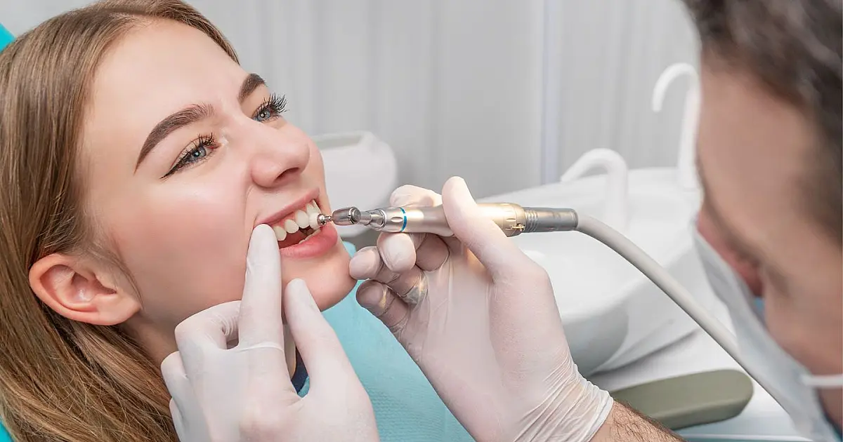 Dentista realizando atendimento odontológico infantil durante avaliação da saúde bucal.